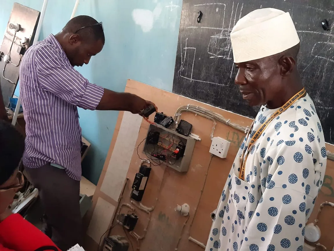 Instructor demonstrating practical work on an electrical training board